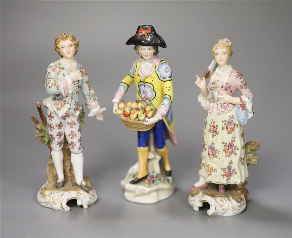 A pair of Continental figurines and a fruit seller, tallest 17cm